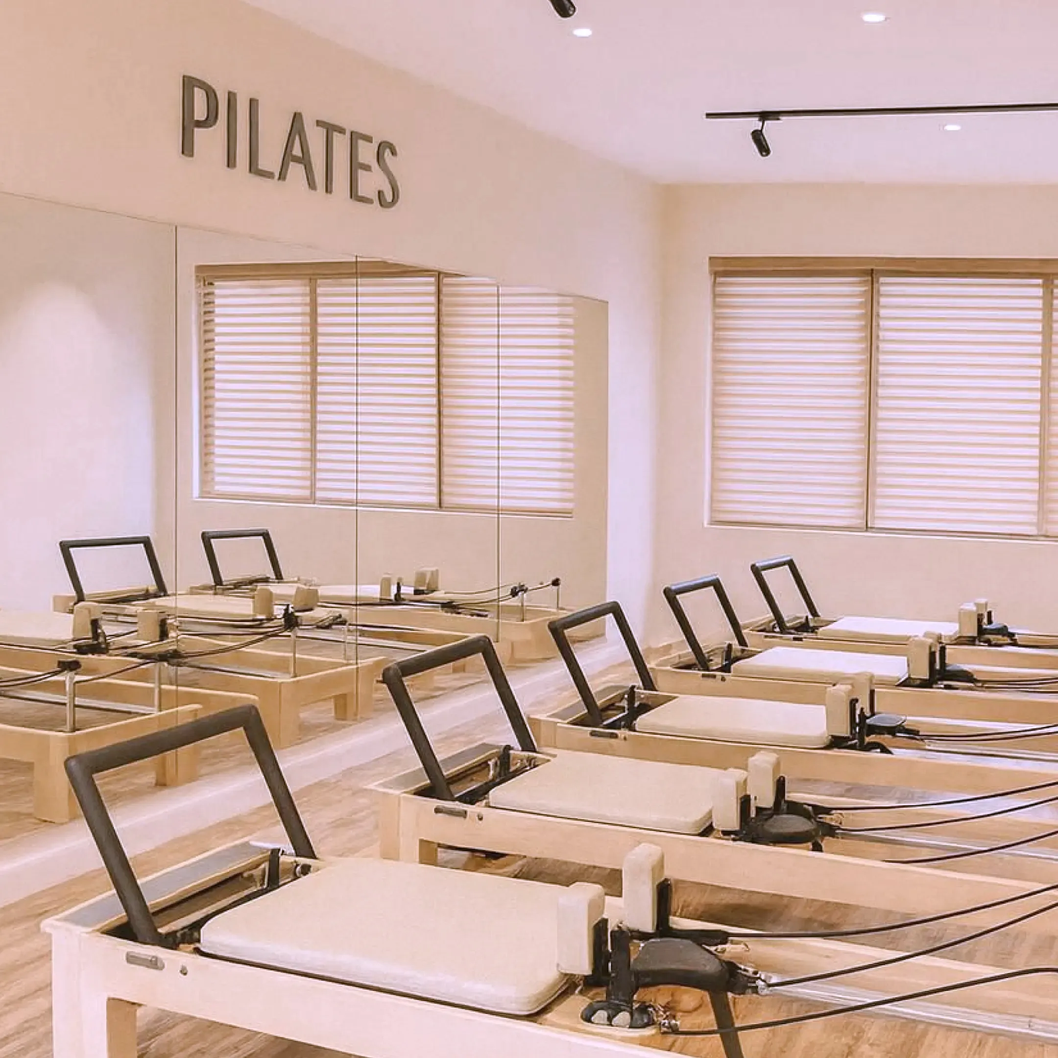 Reformer beds lined up in the bright Blinq Pilates studio